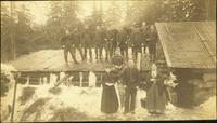 Men and women standing on the roof and in front of a                        building