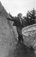 Woman looking out from a rock ledge