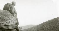 Woman looking out from a rock ledge