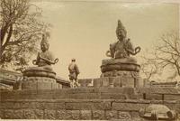 A man paying homage to two Buddhist statues