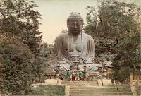 A group of monks under a large Buddhist statue