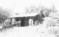 Two adults and a child outside a lodge